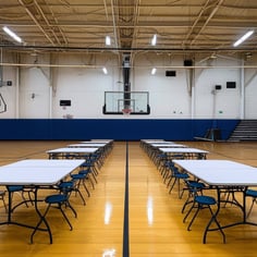 tables and chairs set up in a gym