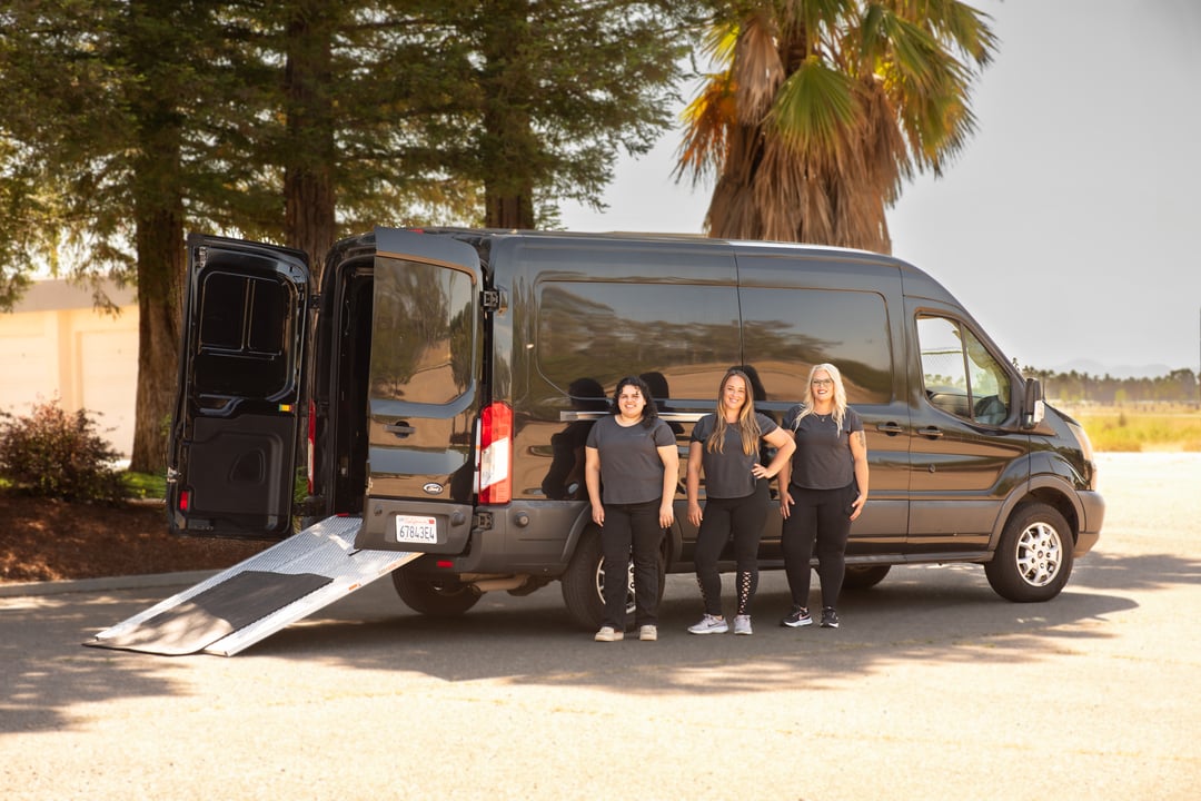 First Aid on the Move training team standing beside their mobile classroom van, equipped with a ramp and ready to deliver on-site CPR and First Aid training.