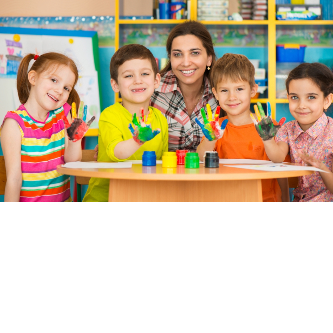 Smiling childcare provider with young children in a classroom—private First Aid and CPR training available in Glenn County for childcare staff, preschools, and early education programs.