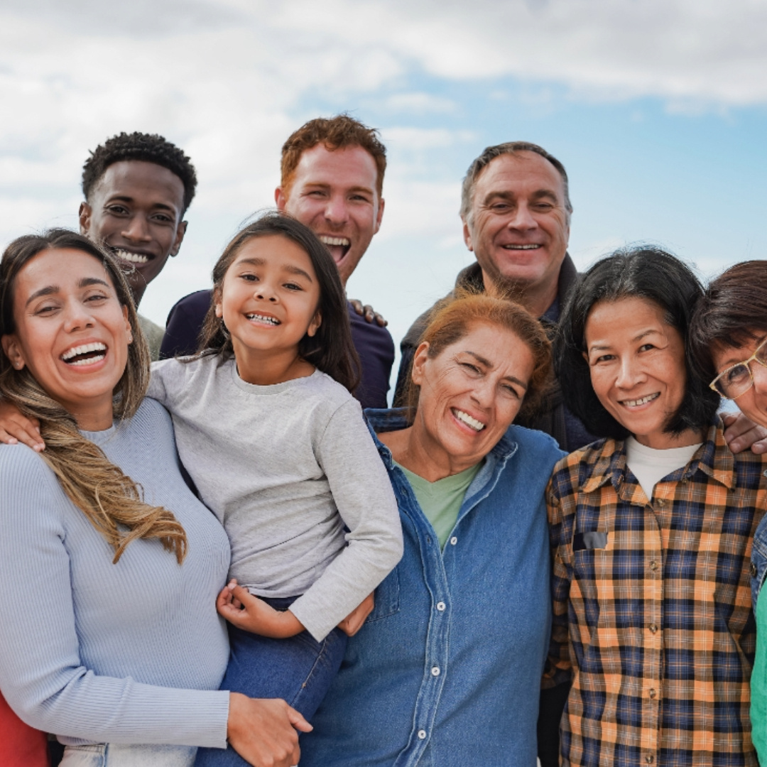  A diverse and joyful group of people sitting together outdoors, smiling and laughing. Bringing First Aid and CPR training to the community, ensuring safety and preparedness for all.